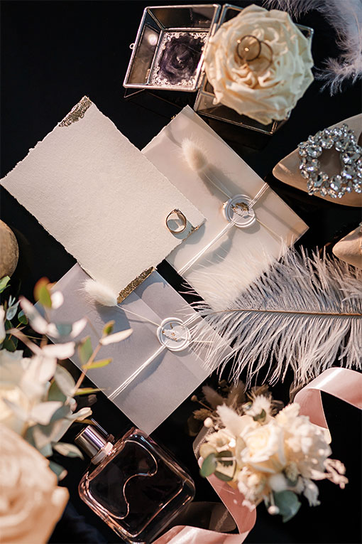 Hochzeitspapeterie mit Accessoires. Elegantes Einladungskartenset in weiß mit Wachssiegel, Trockenblume und Goldakzenten.