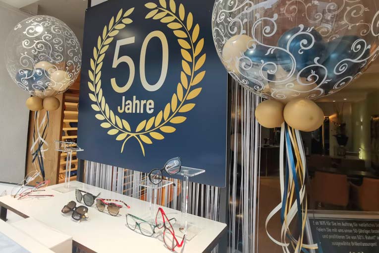 Hübsches junges Paar in eleganter Festkleidung stößt auf einer luxuriösen Sommerparty mit Champagner Gläsern an